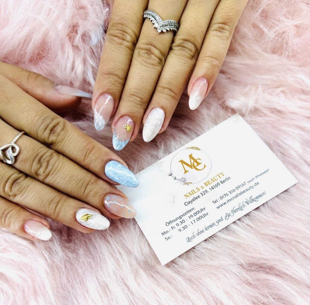 Elegantes Nageldesign Berlin mit Ombre Blau Weiß und filigranen Mustern auf langen Nägeln